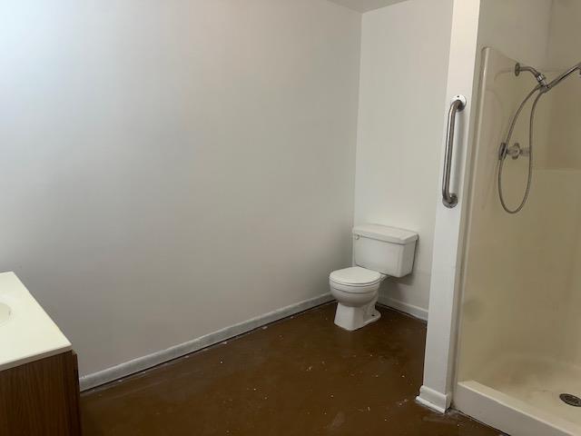 full bathroom with vanity, toilet, concrete flooring, and a stall shower