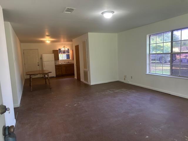unfurnished room with baseboards, visible vents, and concrete floors