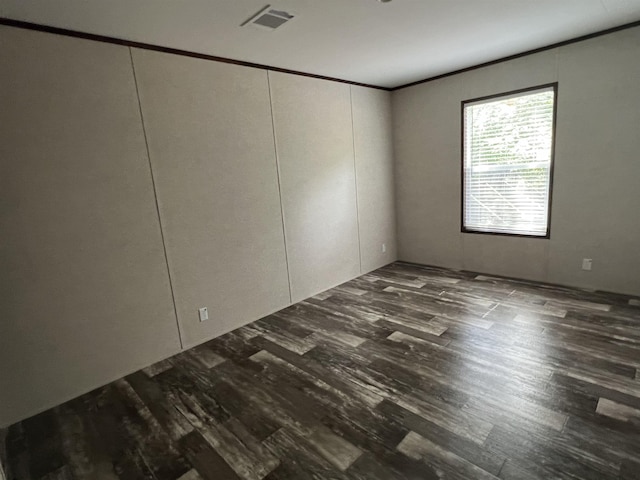 empty room with crown molding and dark wood-type flooring