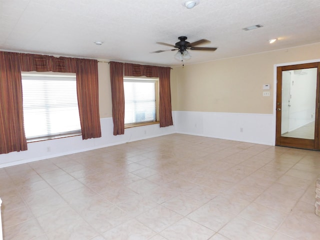 unfurnished room featuring ceiling fan and a textured ceiling