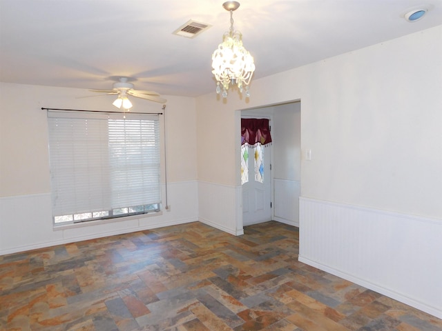 empty room featuring ceiling fan with notable chandelier