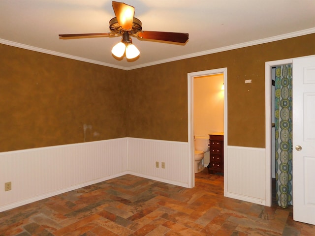 empty room featuring ceiling fan and crown molding