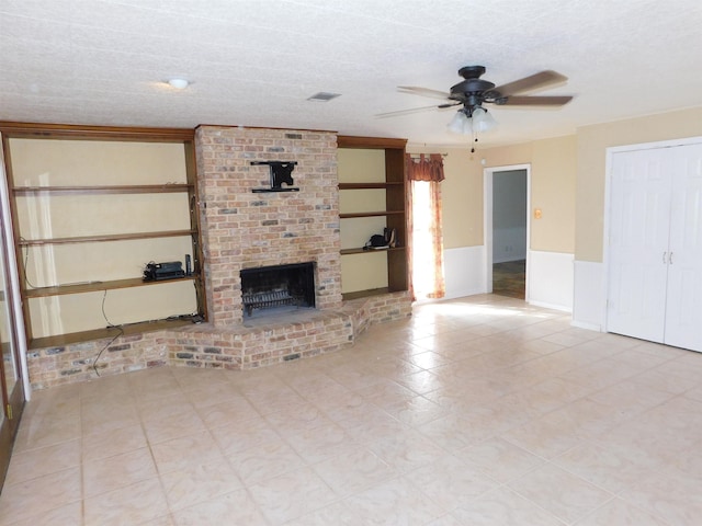 unfurnished living room featuring ceiling fan, a fireplace, and a textured ceiling