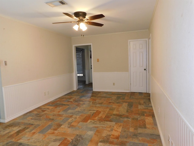 empty room featuring ceiling fan and ornamental molding