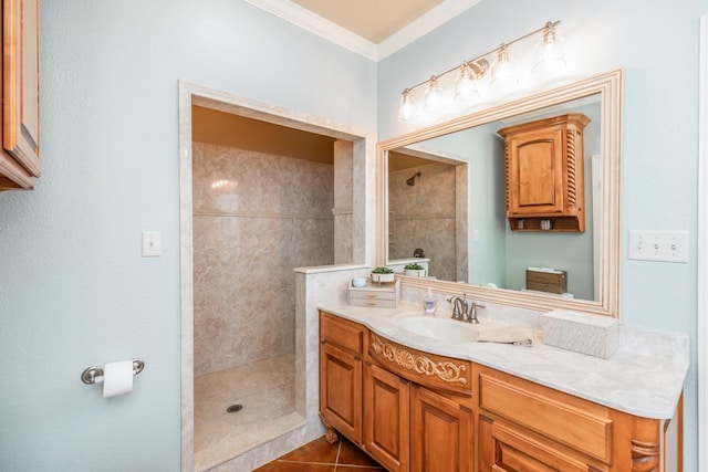 bathroom featuring a tile shower, vanity, tile patterned floors, and ornamental molding