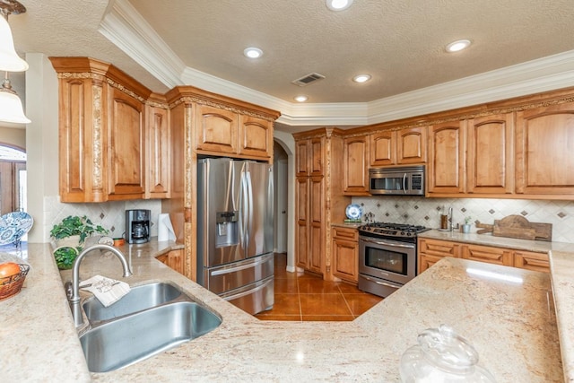 kitchen with sink, stainless steel appliances, pendant lighting, decorative backsplash, and light tile patterned flooring