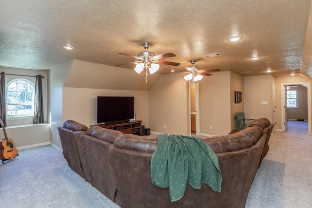 living room with a wealth of natural light, a textured ceiling, light carpet, and vaulted ceiling