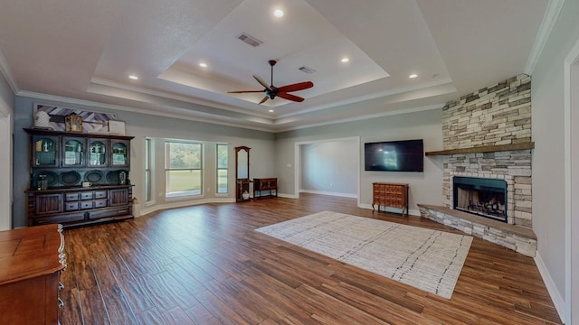 1405 Turner Dr, Bridge City, TX 77611 - living area featuring ceiling fan, a tray ceiling, wood finished floors, crown molding, and a stone fireplace