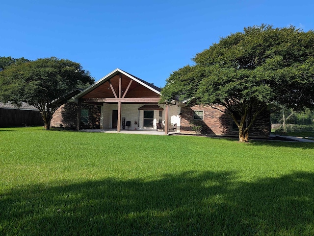 1405 Turner Dr, Bridge City, TX 77611 - rear view of property with a patio, a lawn, and brick siding