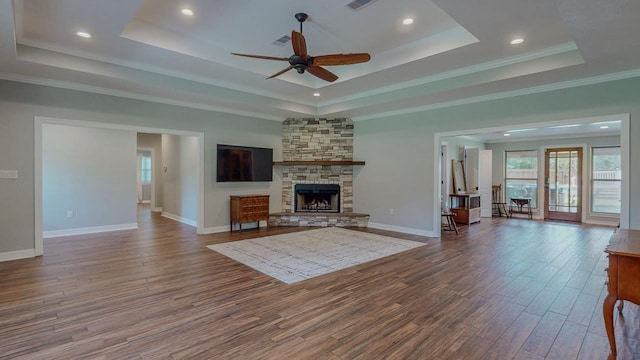 1405 Turner Dr, Bridge City, TX 77611 - living area with a tray ceiling, wood finished floors, a ceiling fan, a stone fireplace, and recessed lighting