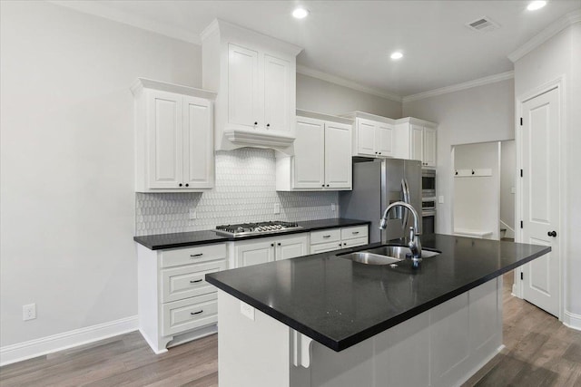 kitchen featuring a center island with sink, white cabinets, and sink