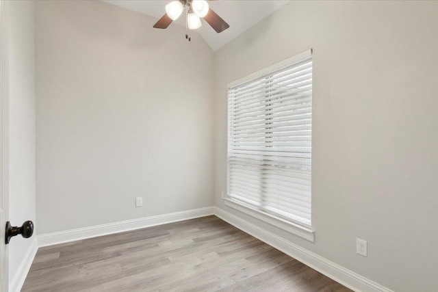 spare room featuring ceiling fan, a healthy amount of sunlight, light wood-type flooring, and lofted ceiling