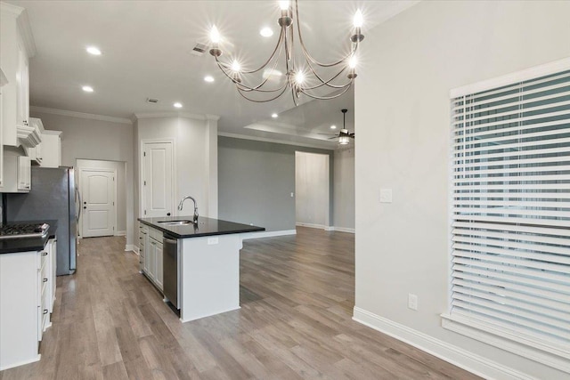 kitchen with stainless steel dishwasher, ceiling fan with notable chandelier, a kitchen island with sink, white cabinetry, and hanging light fixtures