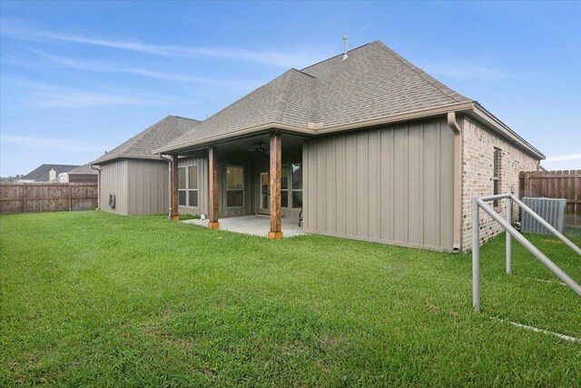 rear view of property with a patio, ceiling fan, and a lawn