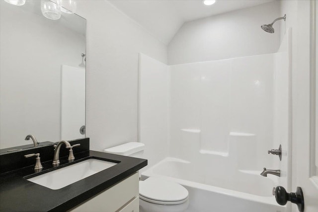 full bathroom with vanity, toilet, lofted ceiling, and shower / washtub combination