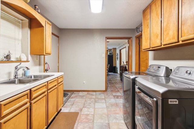 laundry area with cabinets, independent washer and dryer, and sink