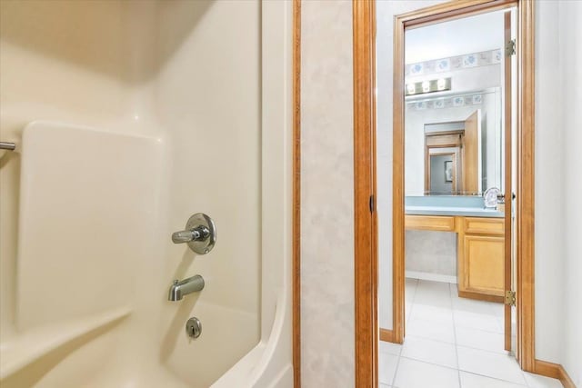 bathroom featuring tile patterned flooring, vanity, and  shower combination