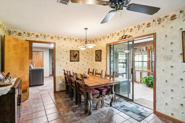 dining area with ceiling fan, dark tile patterned floors, and a textured ceiling