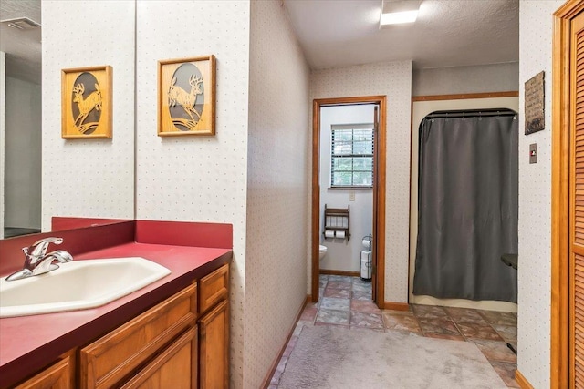 bathroom featuring vanity, curtained shower, and toilet