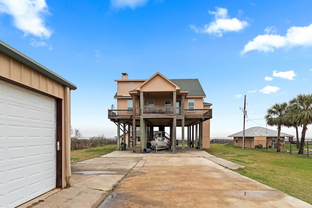 coastal home with covered porch, a garage, stairs, driveway, and a front lawn