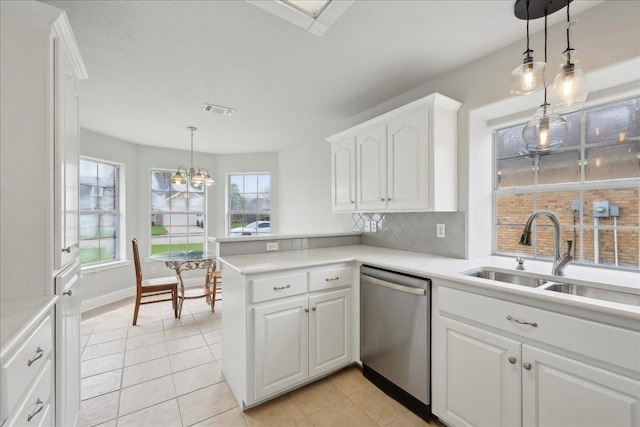 kitchen with backsplash, a sink, white cabinetry, a peninsula, and stainless steel dishwasher
