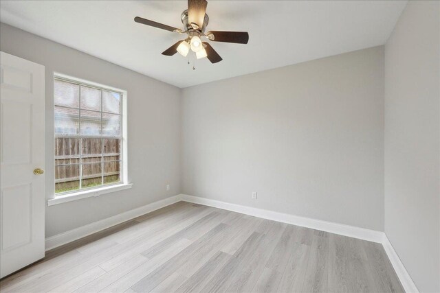 empty room with baseboards, ceiling fan, and light wood finished floors