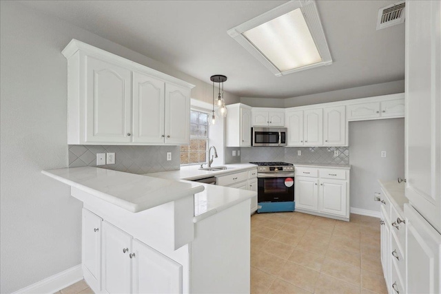 kitchen with white cabinetry, stainless steel appliances, a sink, visible vents, and a peninsula