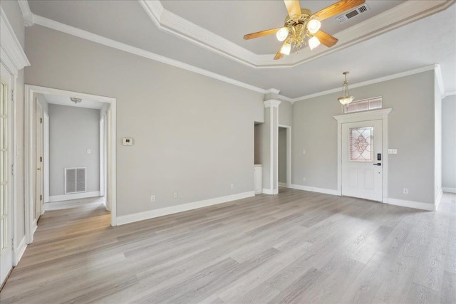 unfurnished living room with a tray ceiling, visible vents, light wood-type flooring, and a ceiling fan