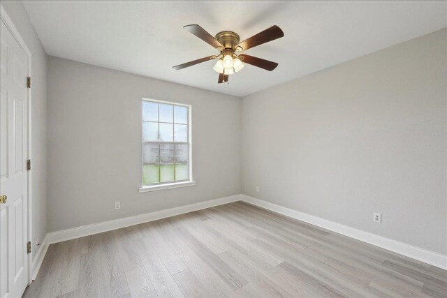 empty room with light wood finished floors, baseboards, and a ceiling fan