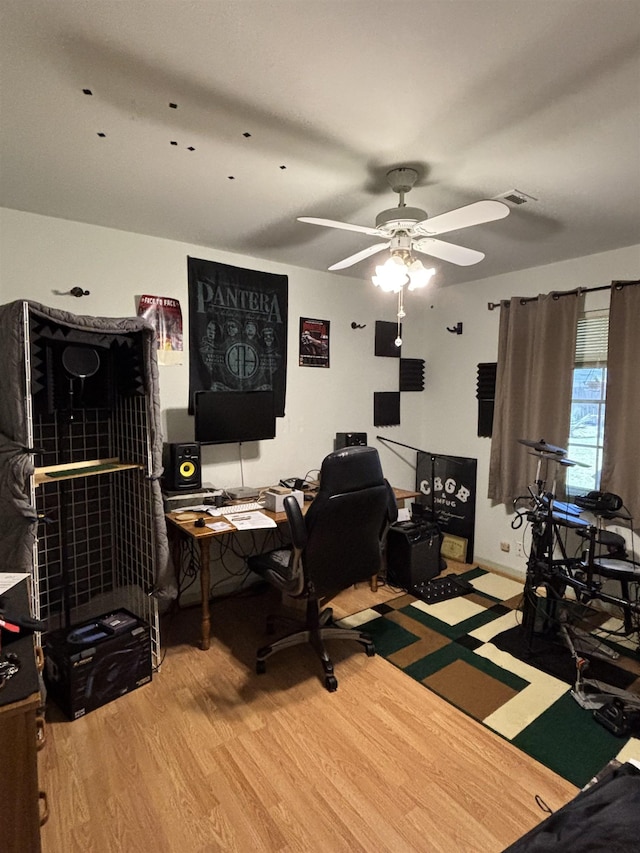 office space with a ceiling fan, wood finished floors, and visible vents