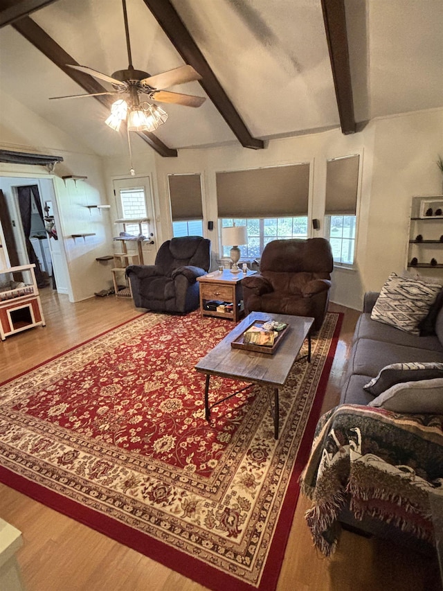 living area featuring plenty of natural light, wood finished floors, and vaulted ceiling with beams