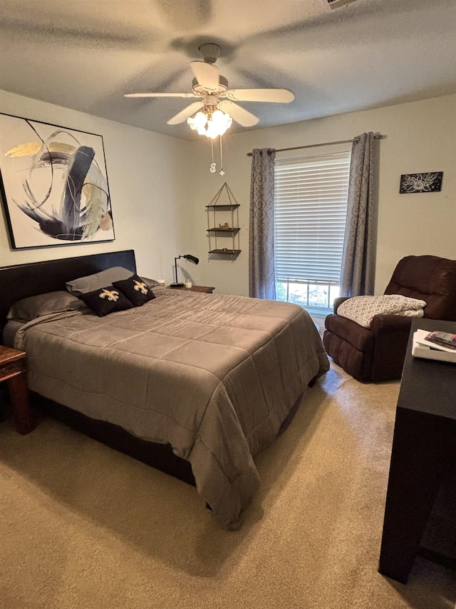 bedroom featuring light carpet, a textured ceiling, and ceiling fan