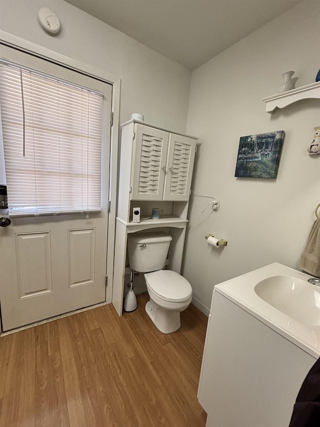 bathroom featuring toilet, wood finished floors, and vanity