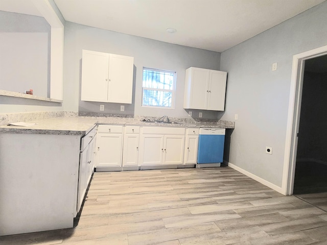 kitchen featuring dishwashing machine, a sink, baseboards, white cabinets, and light wood finished floors