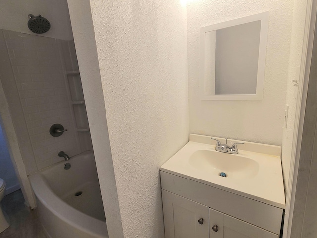 bathroom with a textured wall, vanity, toilet, and shower / bathtub combination