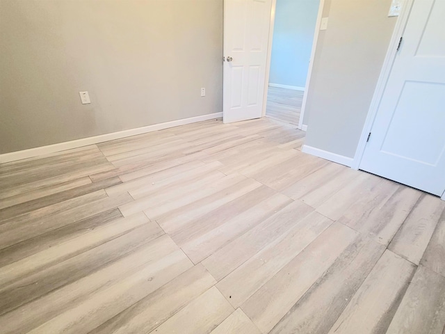 spare room with light wood-style flooring and baseboards