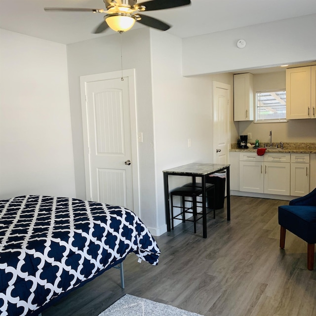 bedroom featuring ceiling fan, sink, and dark hardwood / wood-style floors