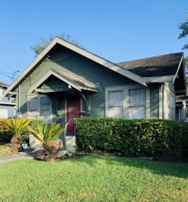 bungalow-style house featuring a front lawn