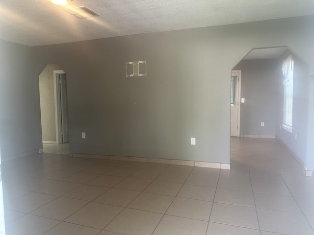 5041 9th St, Port Arthur, TX 77642 - unfurnished room with arched walkways, light tile patterned floors, and a textured ceiling