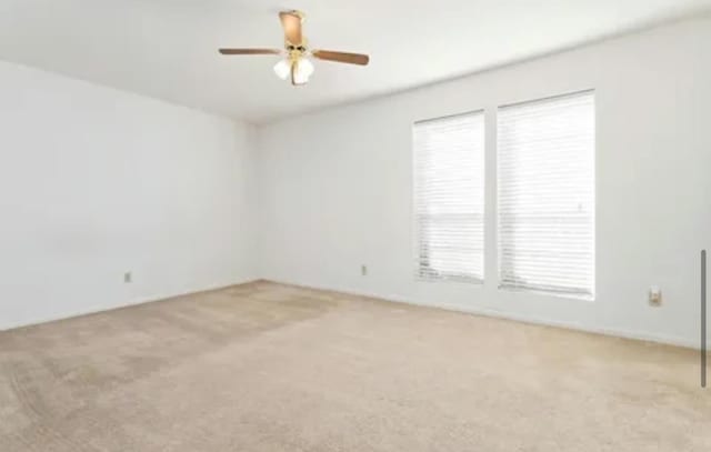 carpeted empty room featuring ceiling fan