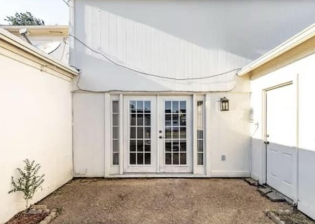 entrance to property featuring french doors and stucco siding