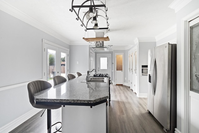 930 Llano St, Port Neches, TX 77651 - kitchen featuring stainless steel fridge, a chandelier, a sink, a breakfast bar area, and dark wood-style floors