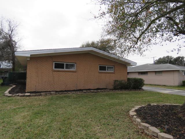 view of side of home with a yard