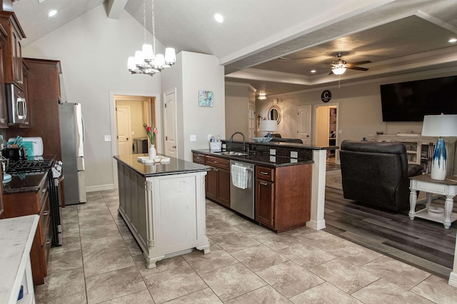 kitchen with a kitchen island with sink, ceiling fan with notable chandelier, sink, appliances with stainless steel finishes, and decorative light fixtures