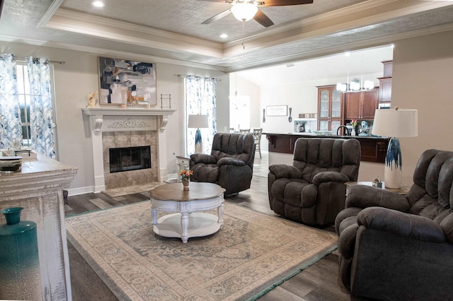 living room with hardwood / wood-style flooring, crown molding, and a tray ceiling