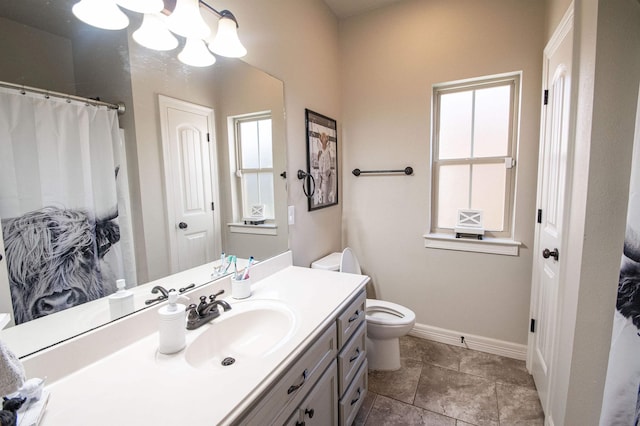 bathroom with tile patterned flooring, vanity, and toilet