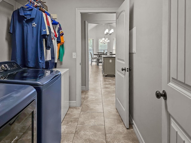 laundry room featuring separate washer and dryer, a chandelier, laundry area, and baseboards