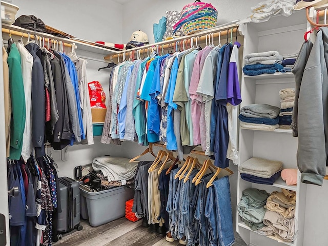 walk in closet with wood finished floors