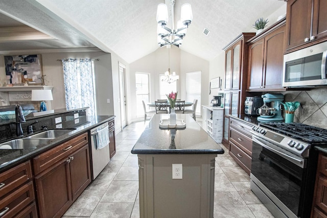 kitchen featuring a textured ceiling, stainless steel appliances, a chandelier, a kitchen island, and hanging light fixtures