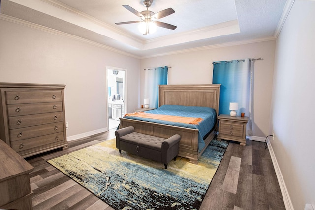 bedroom with ensuite bath, a raised ceiling, ceiling fan, crown molding, and dark hardwood / wood-style floors